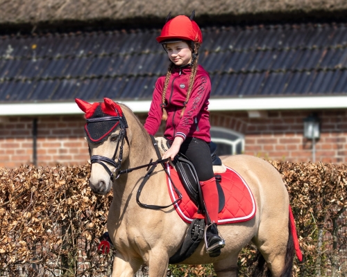 Czapka na kask i inne akcesoria z kolekcji QHP Halloween Diabeł zaprezentowane przez modelkę podczas jazdy konnej