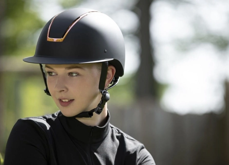 Kask jeździecki w kolorze czarnym z elementami rosegold HKM Lady Shield zaprezentowany przez modelkę