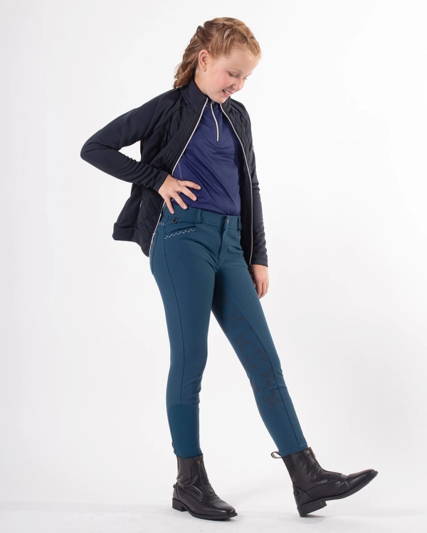 Bryczesy dla dziecka QHP Junior Lauren w kolorze petrol zaprezentowane przez modelkę