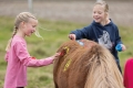 Bawełniana bluzka jeździecka dla dziewczynki HKM Horse Spirit zaprezentowana przez modelkę podczas zabawy z kucykiem