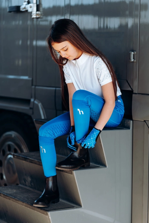 Niebieskie rękawiczki do jazdy konnej dla dzieci Horze Fia zaprezentowane przez modelkę