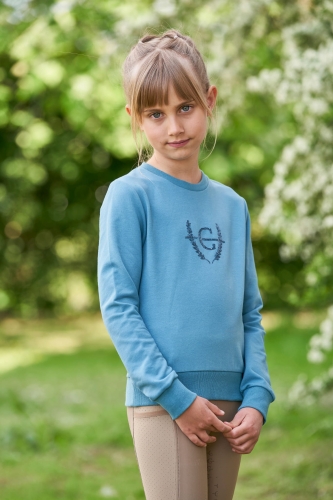 Bluza do jazdy konnej dla dziewczynki Covalliero Junior Aplikacja w kolorze niebieskim zaprezentowana przez modelkę
