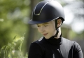 Kask jeździecki w kolorze czarnym z elementami srebrnymi HKM Lady Shield zaprezentowany przez modelkę