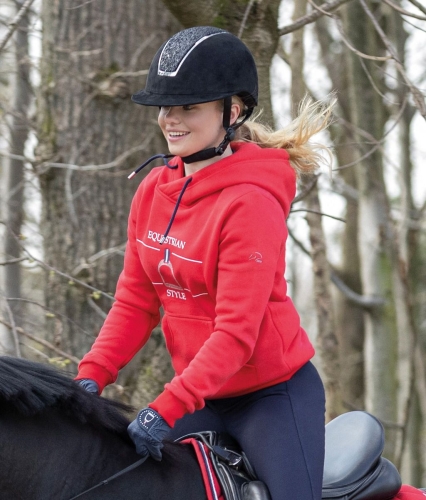Bluza jeździecka HKM Equine Sports w kolorze czerwonym zaprezentowana przez modelkę  podczas jazdy konnej