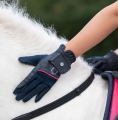 Rękawiczki jeździeckie dziecięce HKM Junior Aymee w kolorze granatowym zaprezentowane przez modelkę podczas jazdy konnej