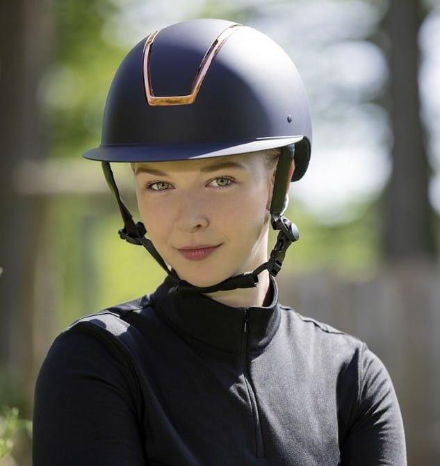 Kask jeździecki w kolorze granatowym z elementami rosegold HKM Lady Shield zaprezentowany przez modelkę