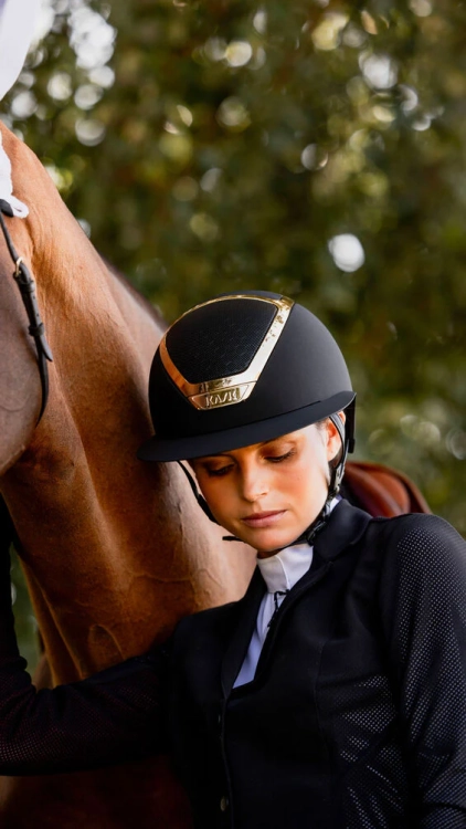 Kask jeżdziecki firmy Kask model Star Lady Chrome w kolorze Black/Gold zaprezentowany przez modelkę