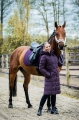 Płaszcz jeździecki Schockemohle Kyra w kolorze deep mauve zaprezentowany przez modelkę z koniem