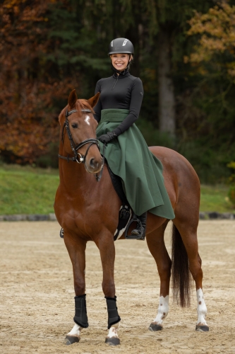 Koszulka termiczna jeździecka Covalliero Active w kolorze black zaprezentowana przez modelkę podczas jazdy konnej