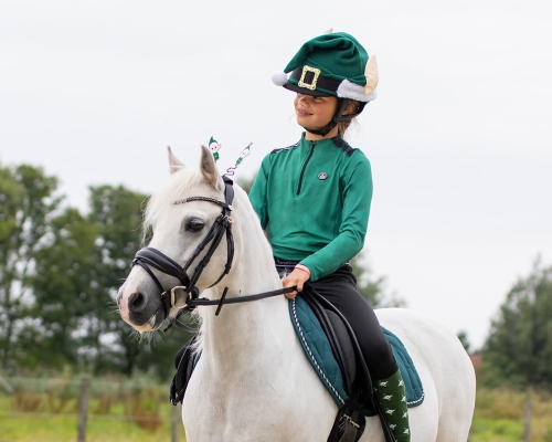 Czapka na kask QHP Christmas Elf zaprezentowana przez modelkę podczas jazdy konnej