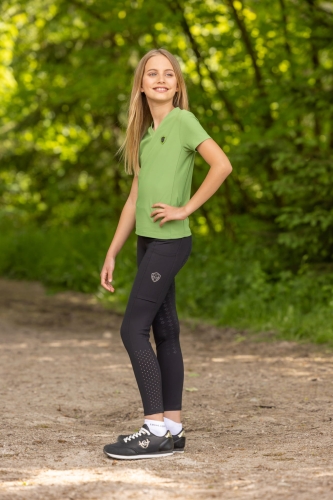 Koszulka jeździecka polo dla dziewczynki w kolorze zielonym Covalliero Junior zaprezentowana przez modelkę