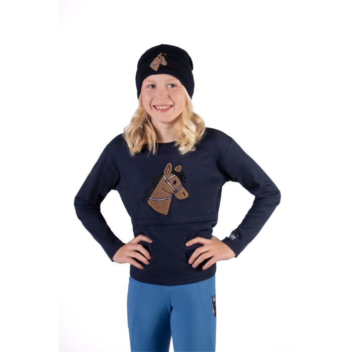Bluzka jeździecka dziecięca HKM Junior z innymi akcesoriami z kolekcji Mia zaprezentowane przez modelkę