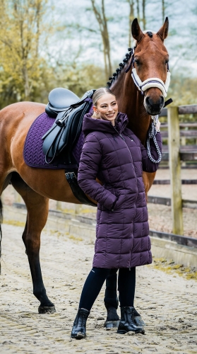 Płaszcz jeździecki Schockemohle Kyra w kolorze deep mauve zaprezentowany przez modelkę z koniem